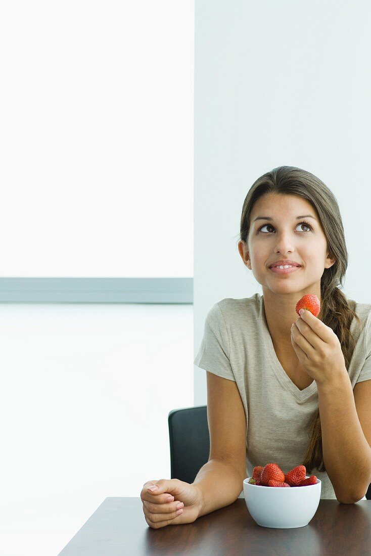 Young woman eating strawberries