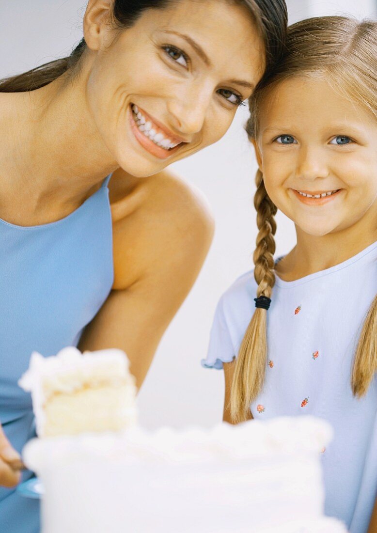 Mutter und Tochter mit angeschnittenem Kuchen