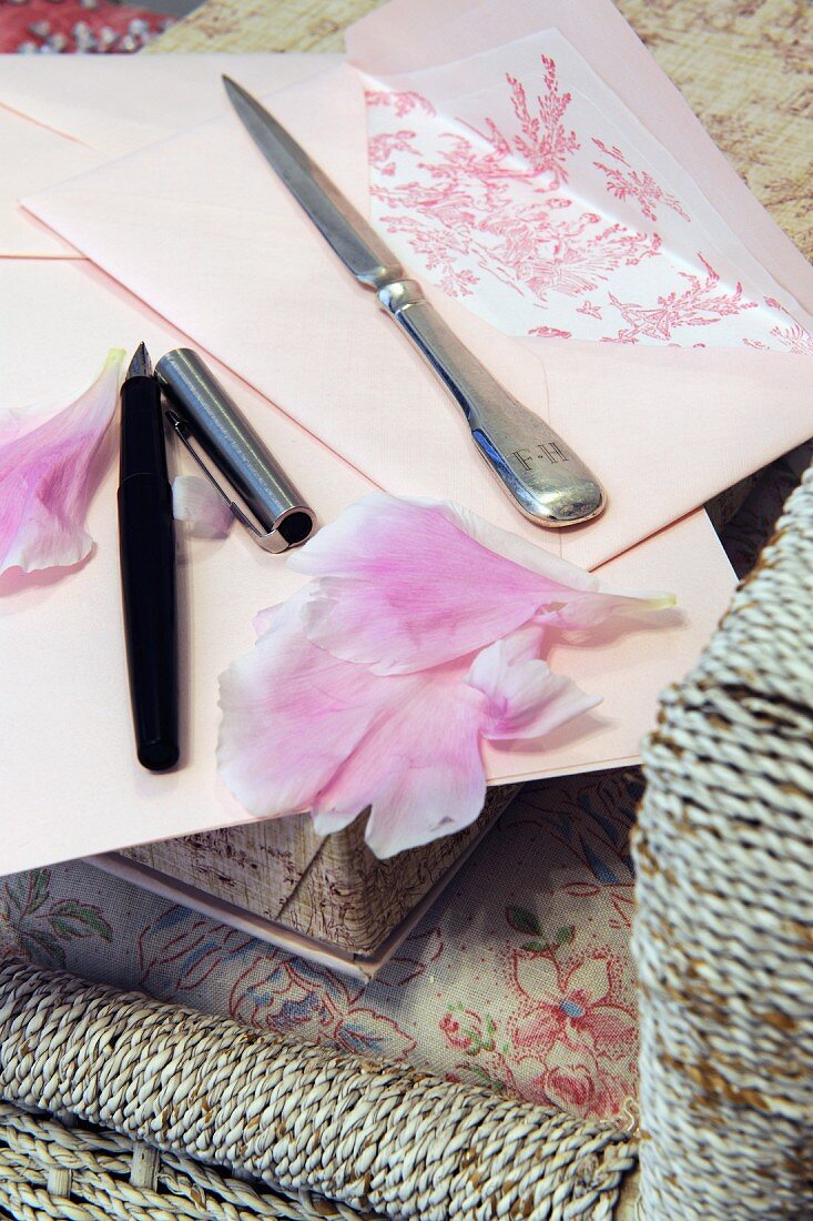 Letter, rose petals, stylograph and letter opener on chair