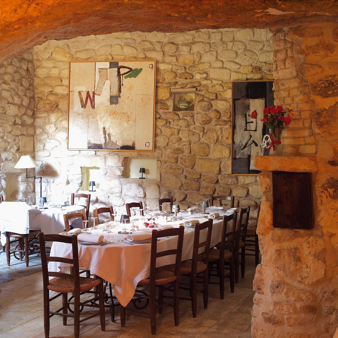 Gedeckter Tisch vor Natursteinwand im Speisesaal