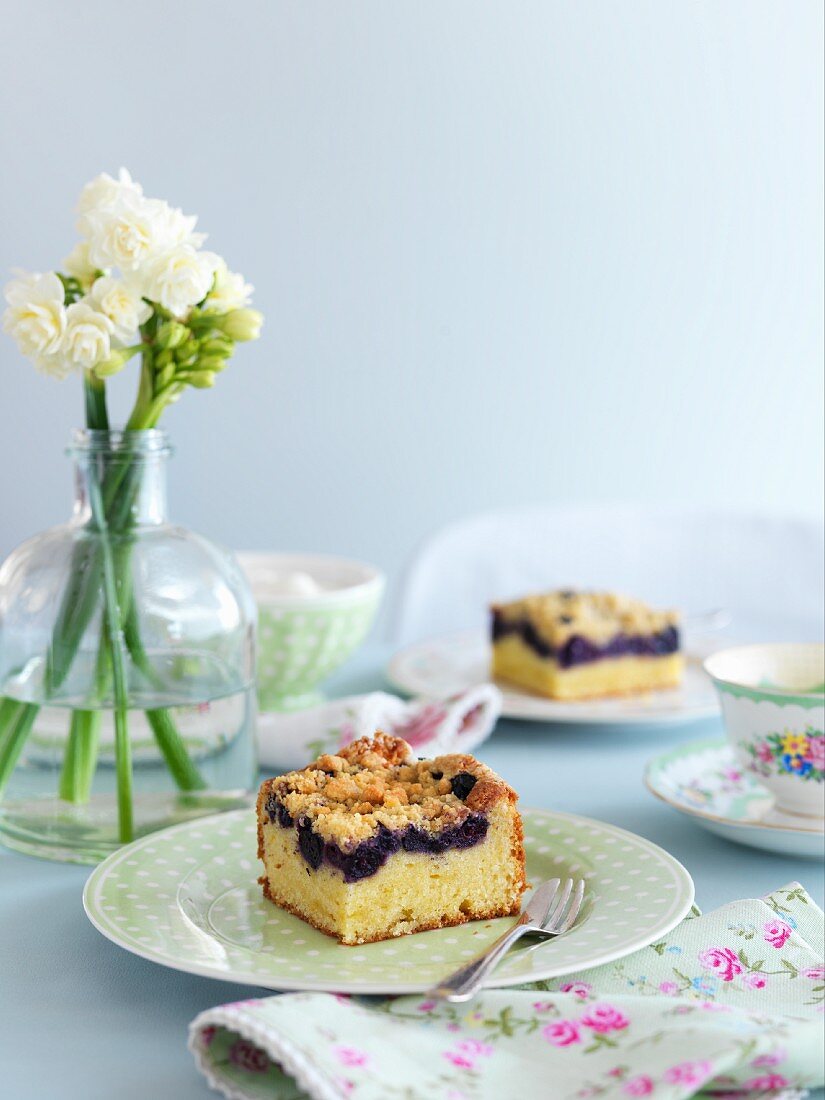 A table laid with blueberry tray bake cake