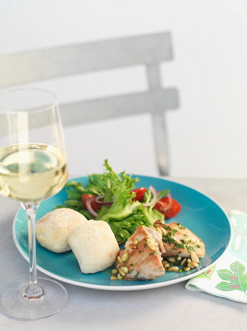 Chicken thighs with pine nuts, bread and salad