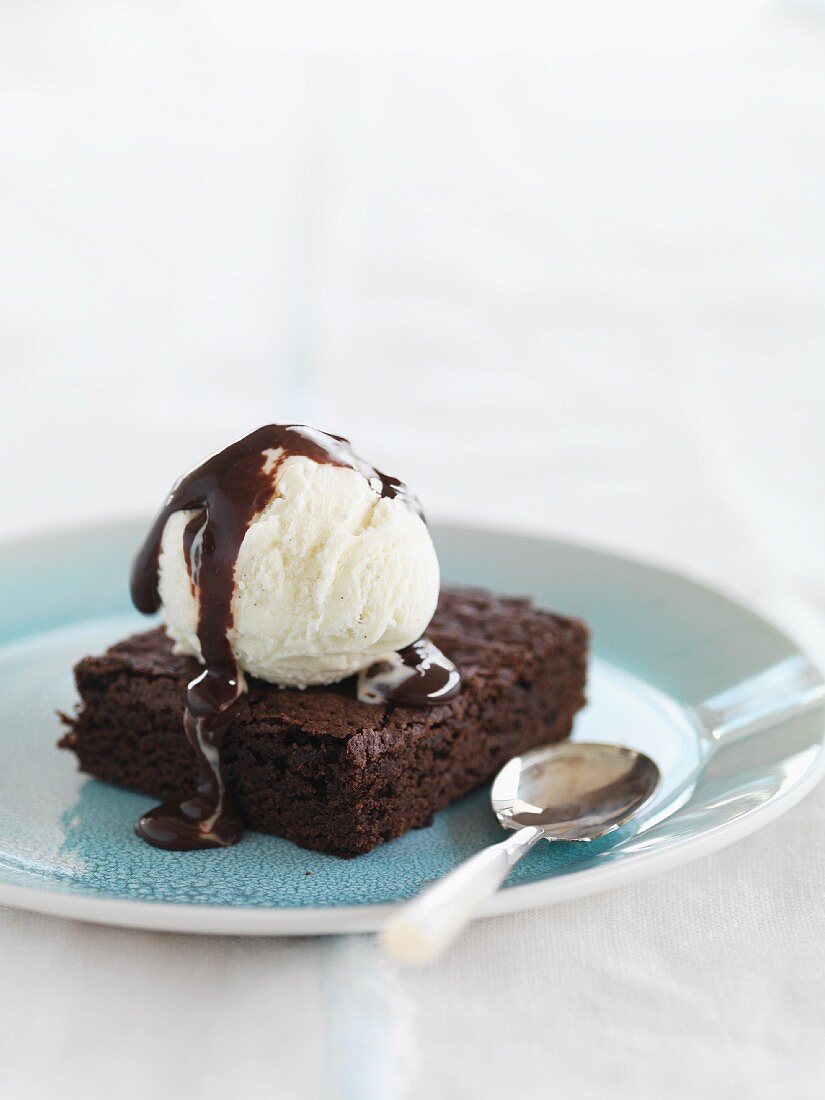 A brownie with vanilla ice cream and chocolate sauce