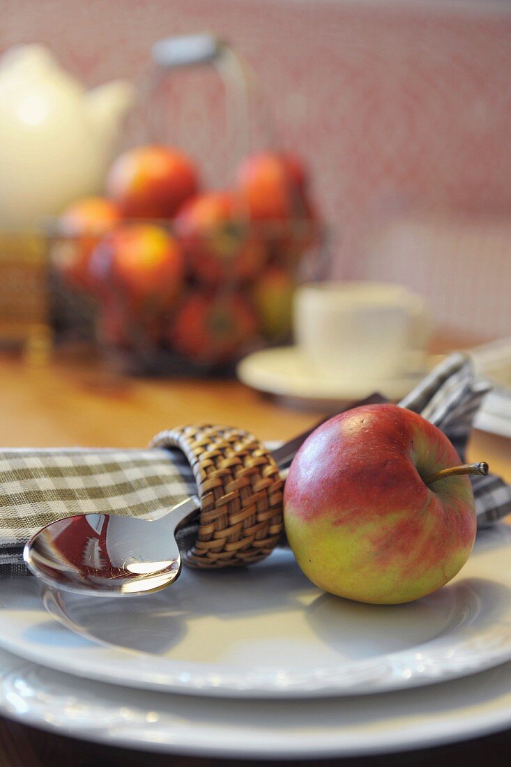 Apple, spoon and napkin on plate