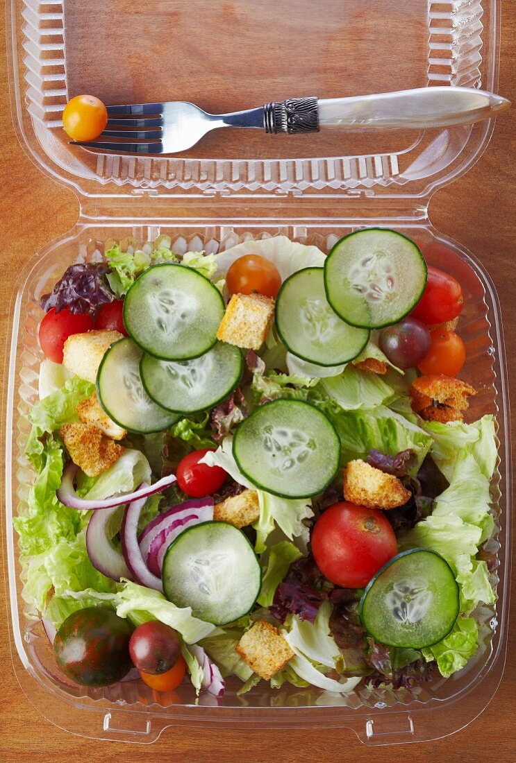 Gemischter Salat mit Croûtons im Plastikbehälter zum Mitnehmen