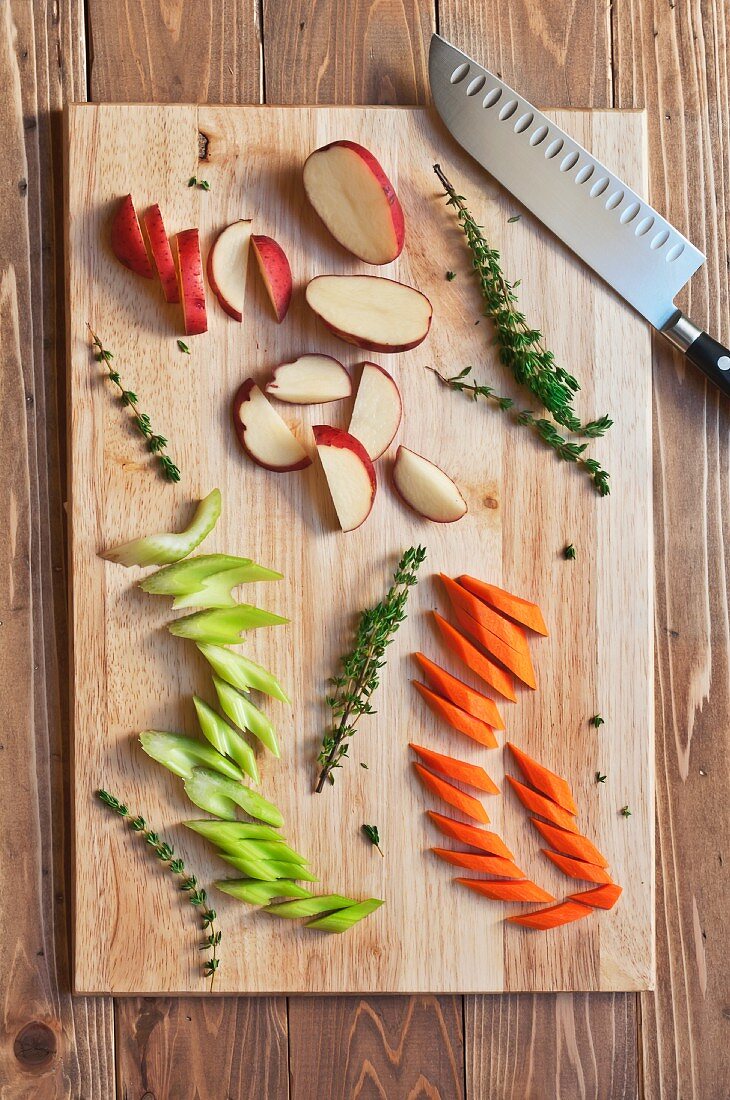 Chopped Red Potato, Carrots and Celery with Thyme on a Cutting Board; From Above