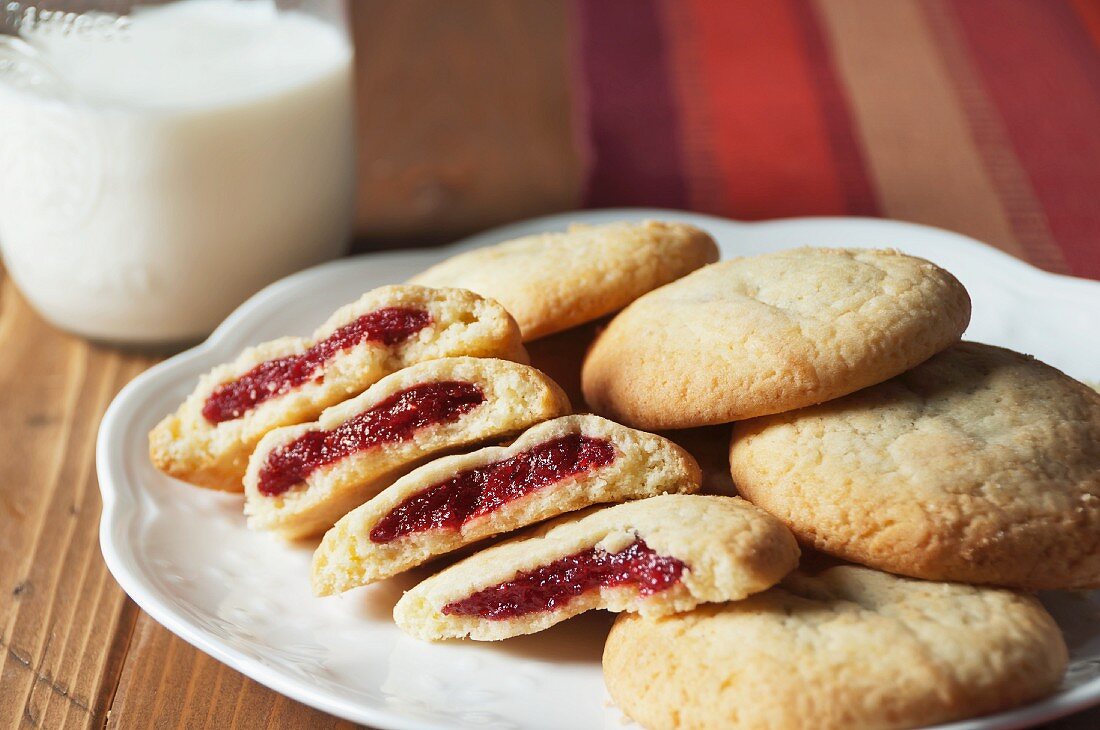 Raspberry Jam Stuffed Pillow Cookies on a Platter; Glass of Milk