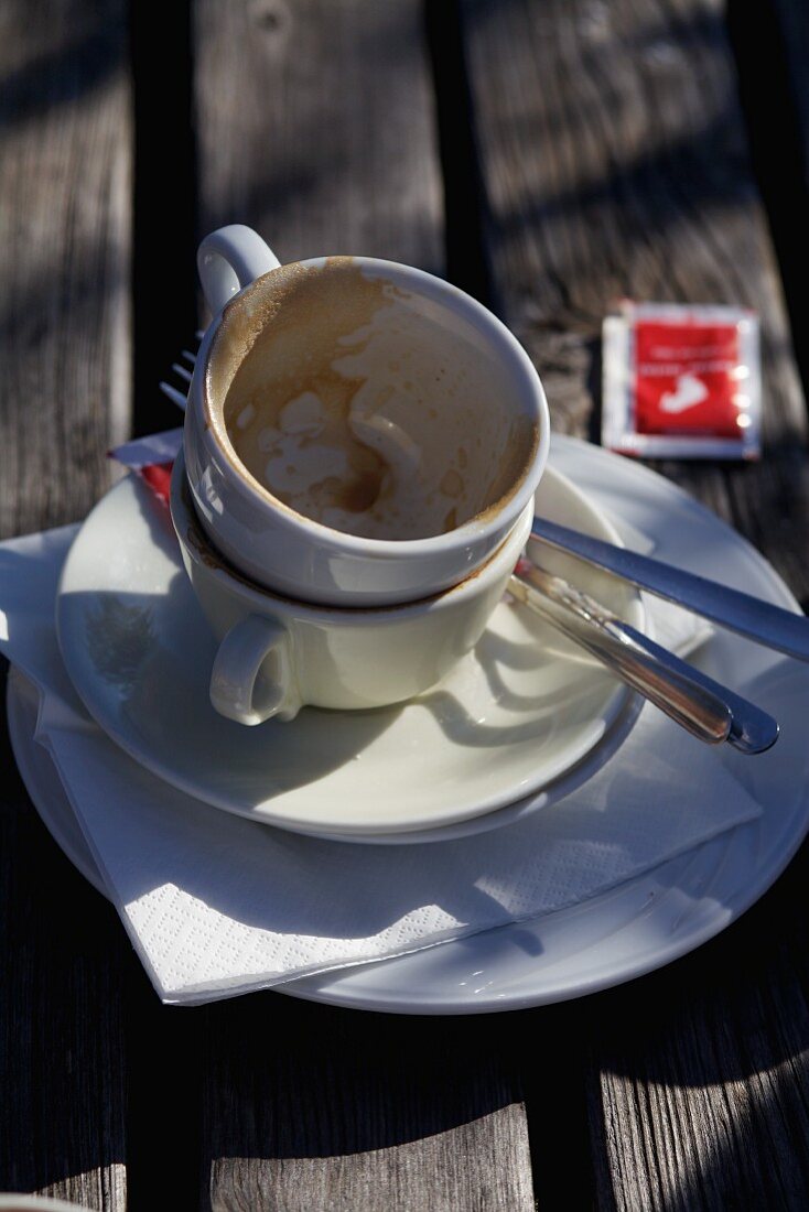 Zwei leere, benutzte Kaffeetassen auf Tisch im Freien