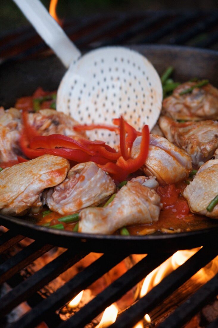 Paella in a large pan on an open fire