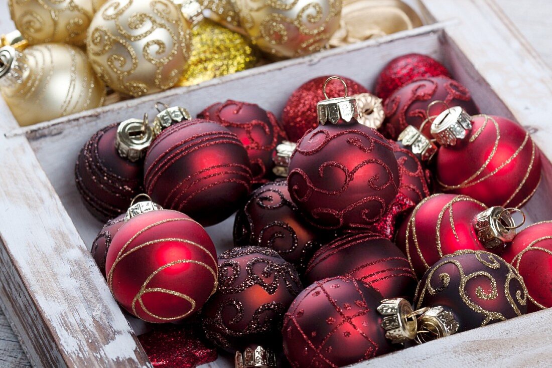 Verschiedene Christbaumkugeln in Holzkiste