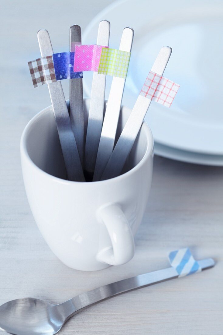 Teaspoons marked with masking tape in a porcelain mug