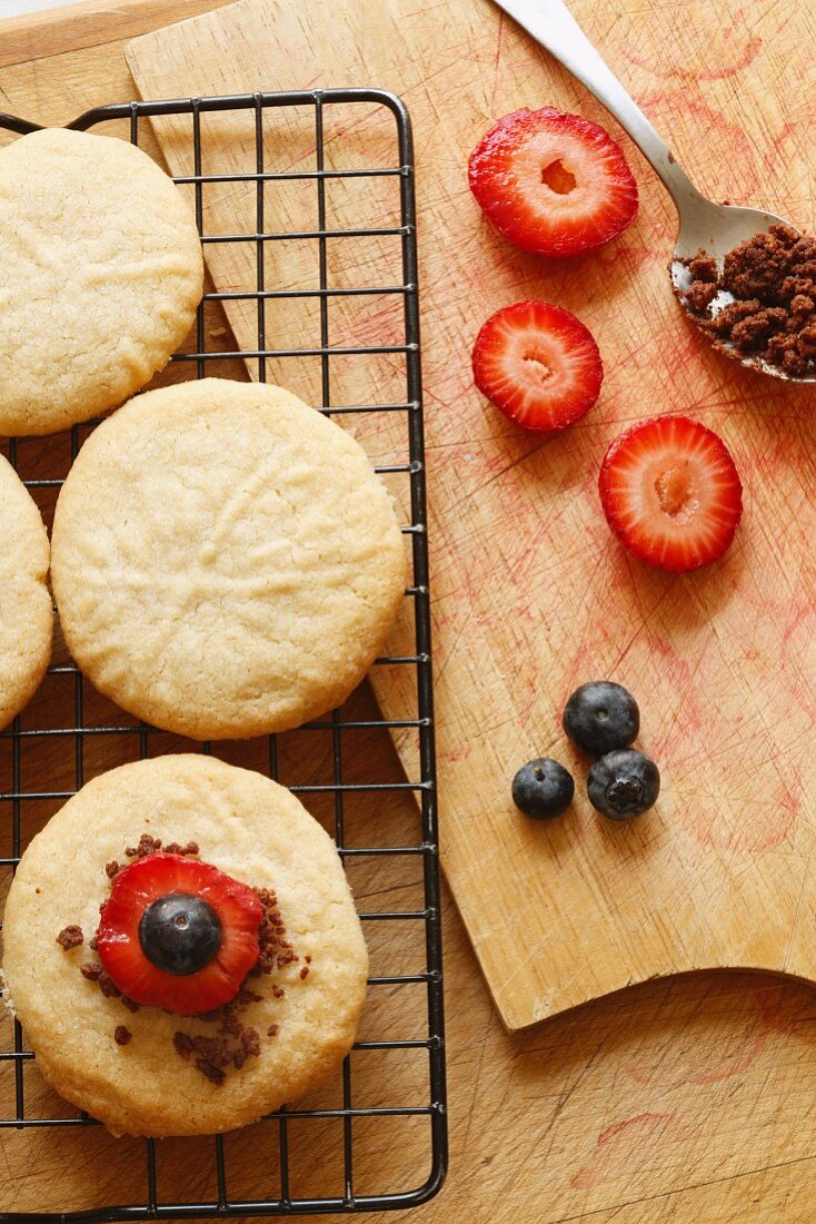 Cookies Cooling on a Cooling Rack with Strawberries, Chocolate and Blueberries; From Above
