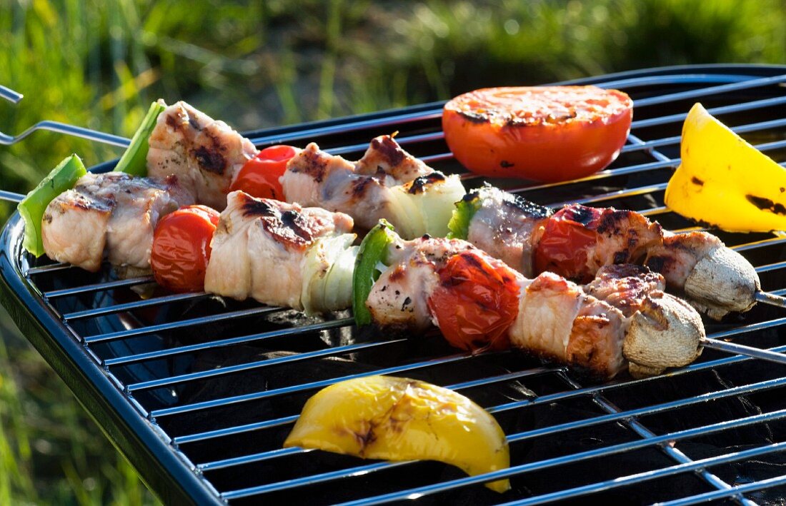 Pork kebabs, pepper and tomatoes on a barbecue