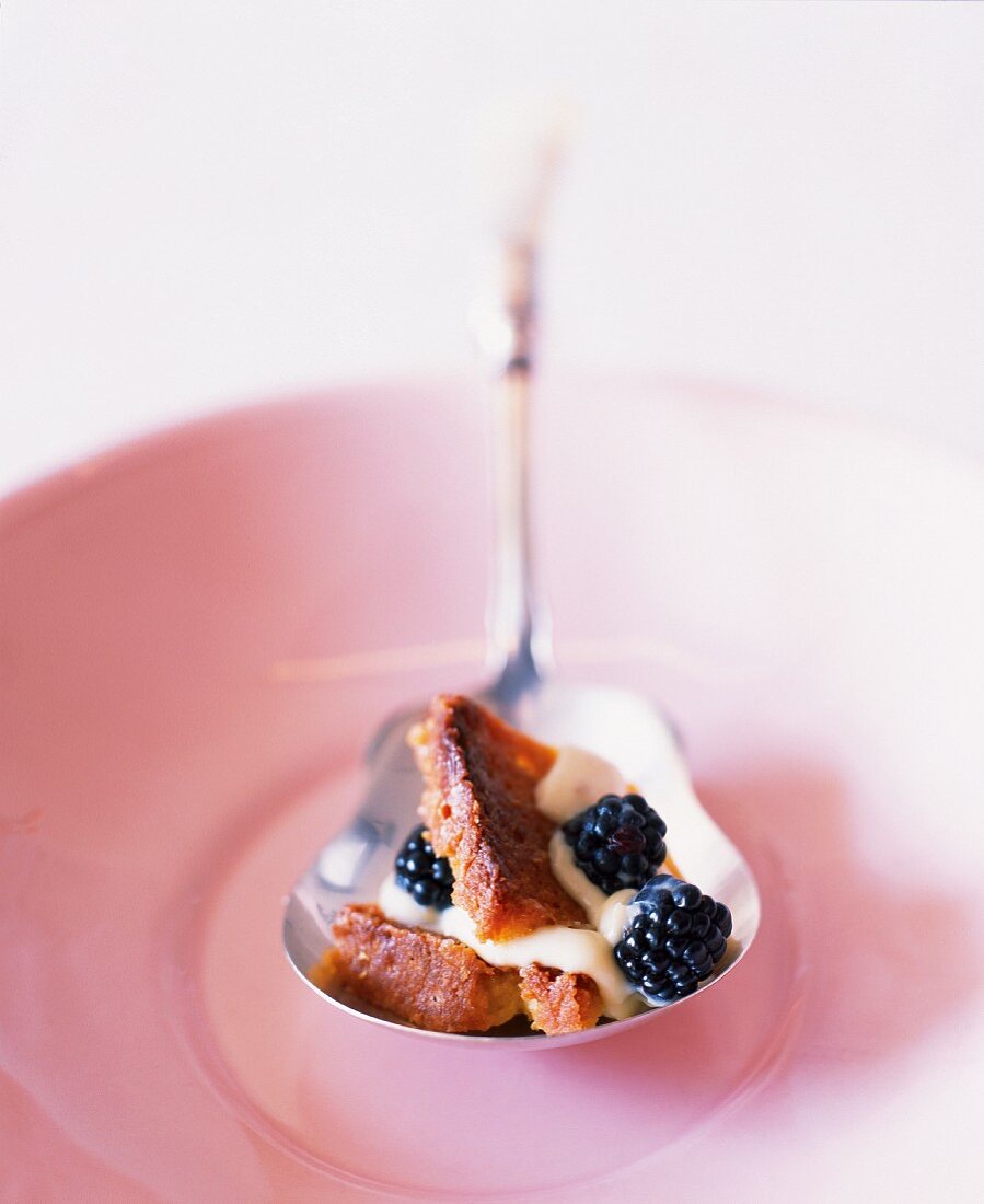 Ein Löffel Maisbrotpudding mit Brombeeren