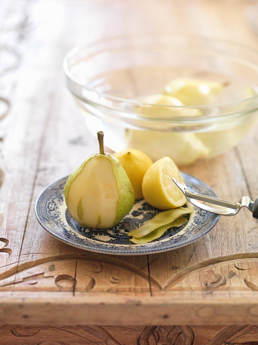 A pear being peeled and placed in lemon water
