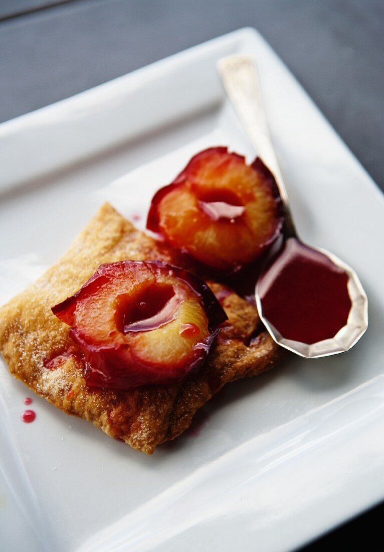 Roasted plums with sauce on pastry