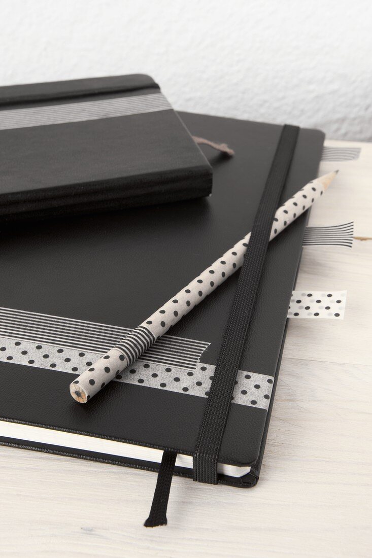 A notebook and pencil decorated with masking tape