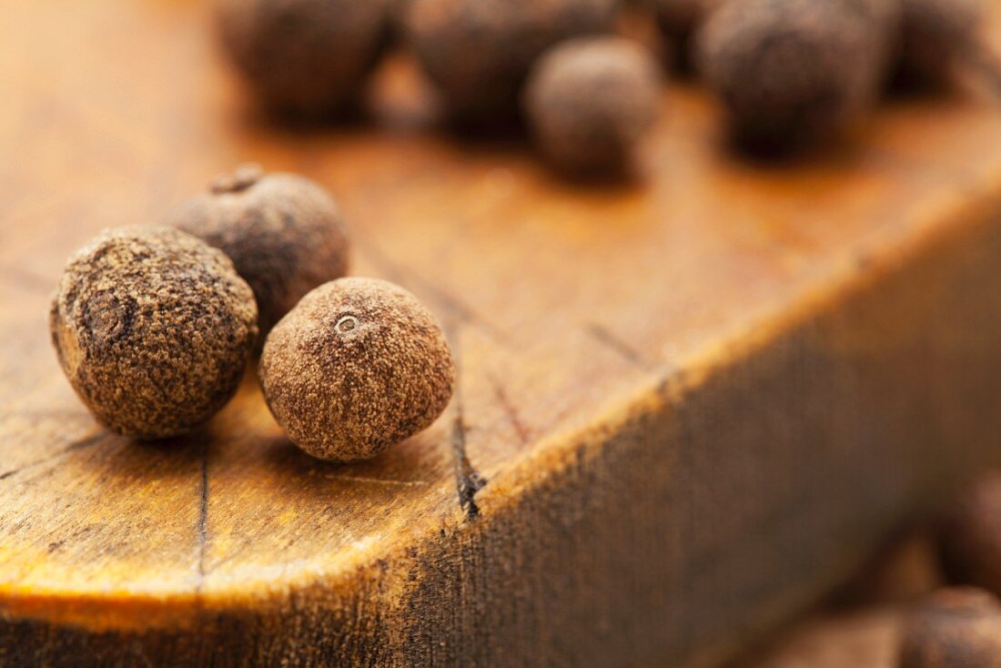 Allspice berries on a chopping board (close-up)