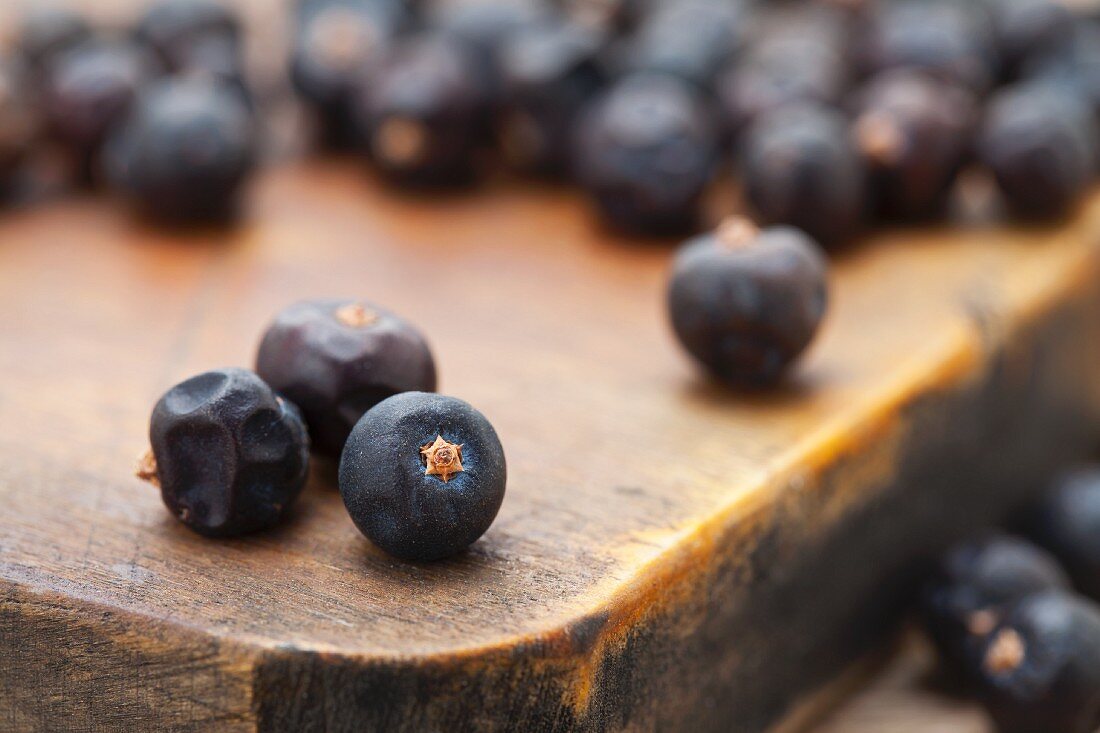 Juniper berries on chopping board (close-up)