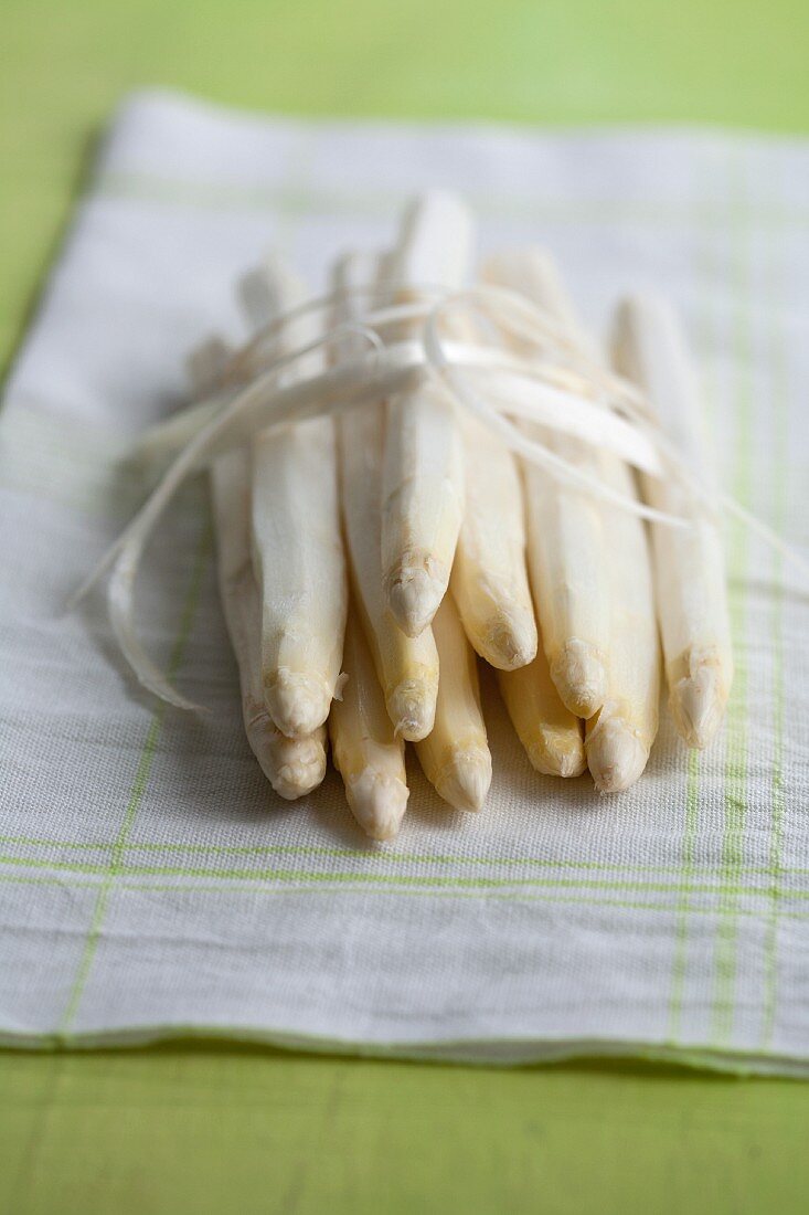 Peeled white asparagus with peel on a kitchen towel