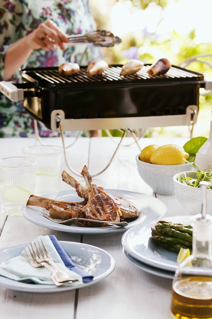 A table laid outside with grilled lamb chops