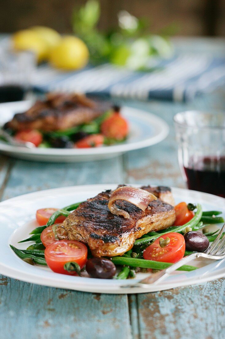 Rindersteak mit Anchovi, grünen Bohnen, Tomaten und Oliven