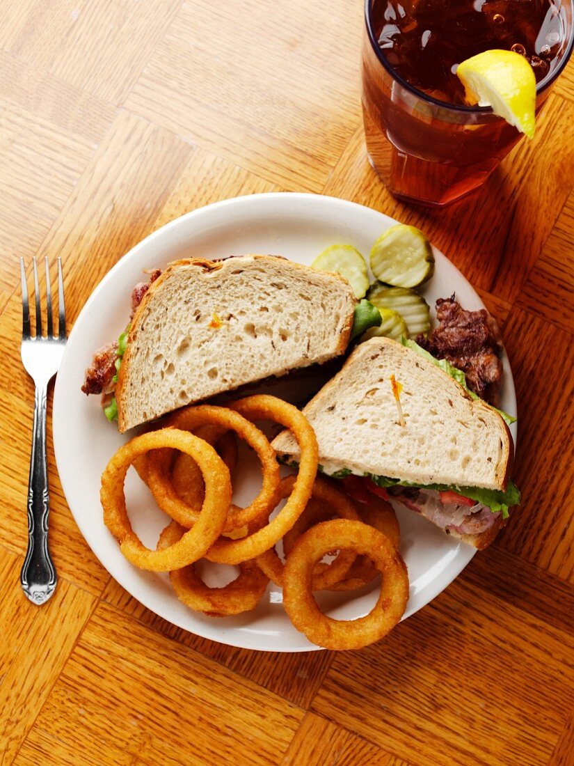 Steak-Sandwich mit frittierten Zwiebelringen und Eistee