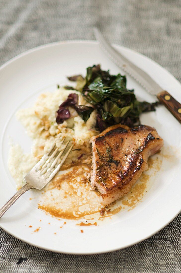 Partially Eaten Pork Chop with Mashed Potato and Braised Greens