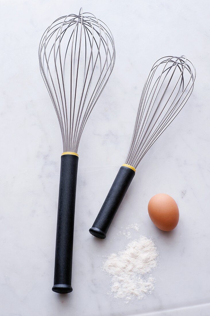 Two whisks, eggs and flour