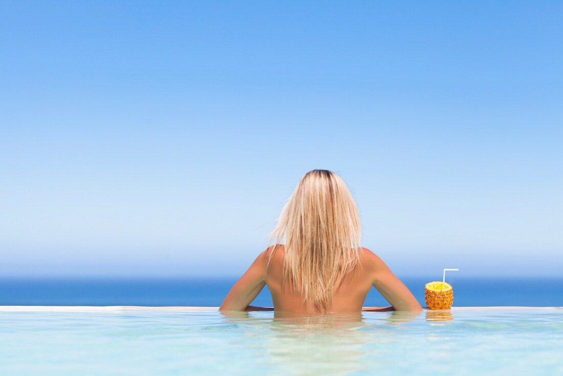 Woman relaxing with drink in pool