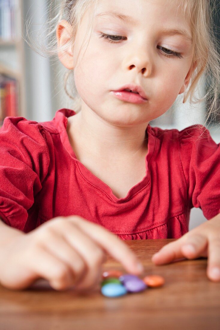 Girl playing with candies on table