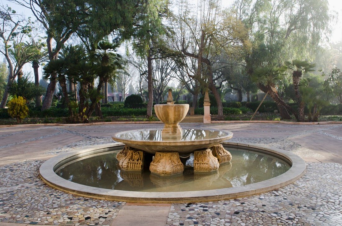 Platz mit altem Zierbrunnen in mediterranem Garten