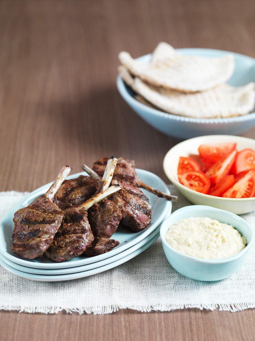 Grilled lamb chops with hummus, tomatoes and unleavened bread