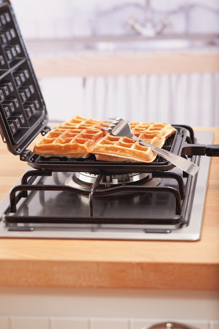 Waffeleisen mit frisch gebackenen Waffeln