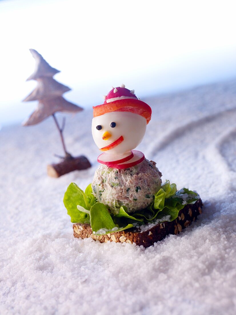 A snowman made of tuna spread and a boiled egg on wholemeal bread