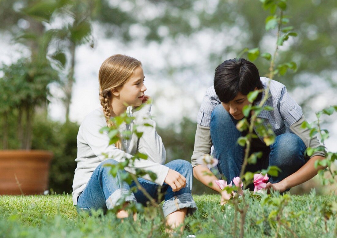 Frau und Kind sitzen auf der Wiese im Garten