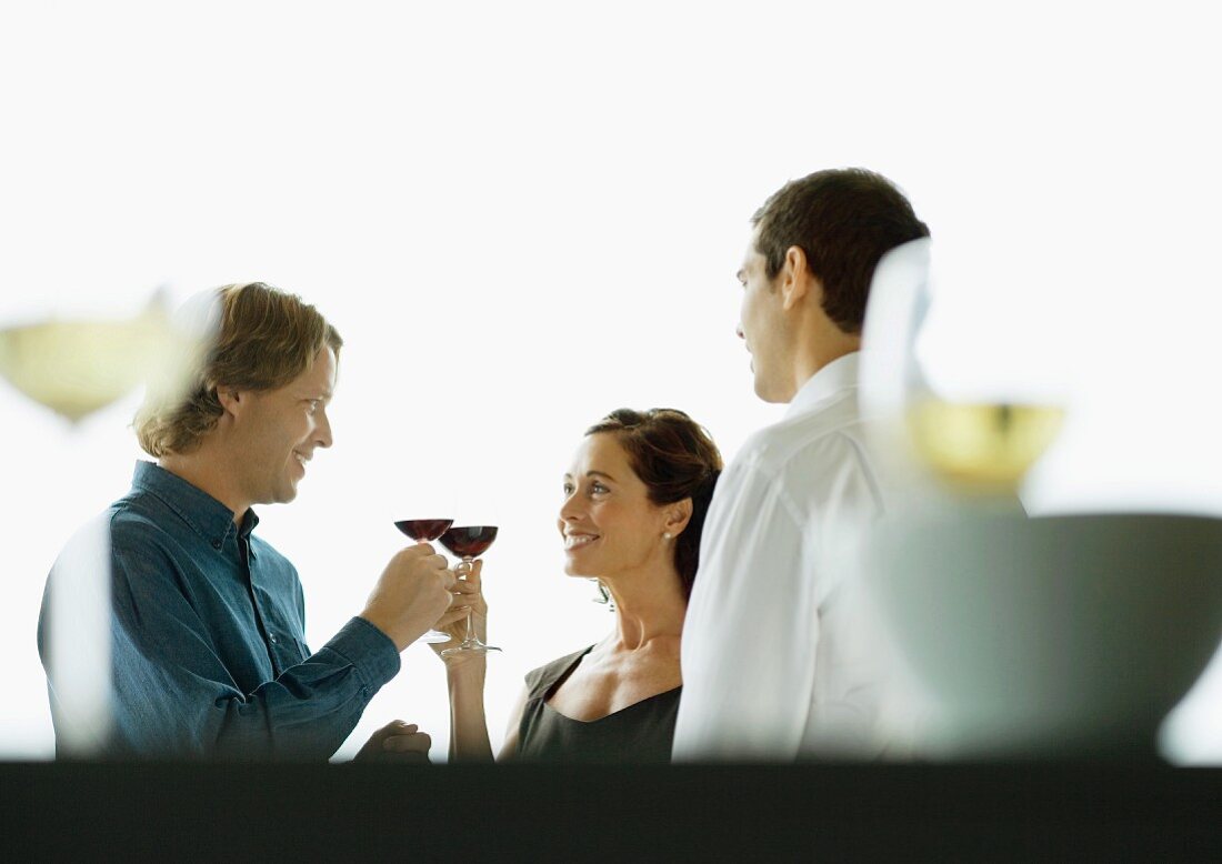 Man and woman clinking glasses during party