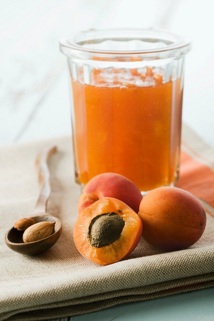 Frische Aprikosen und ein Glas Aprikosenmarmelade