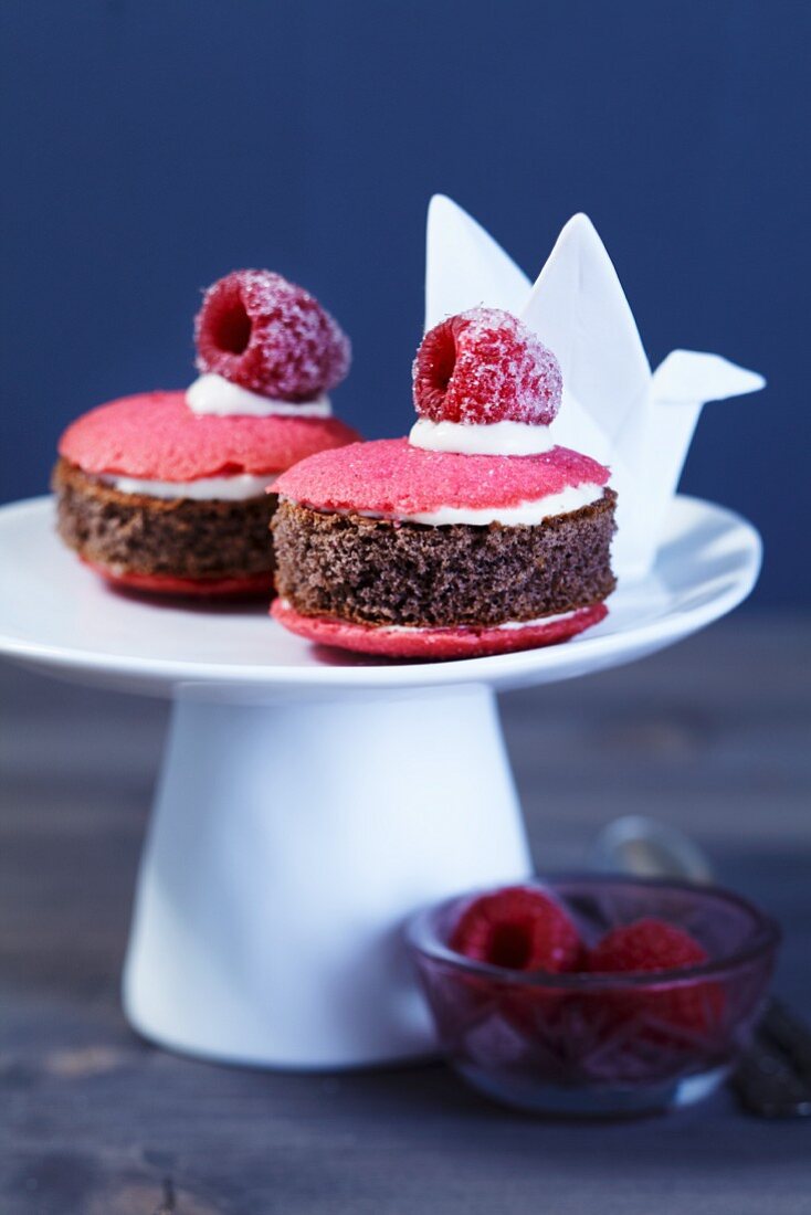 Miniküchlein auf Etagere mit gezuckerten Himbeeren