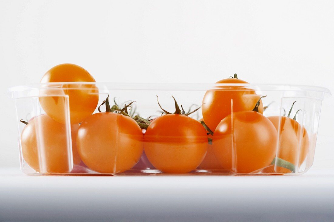 Gelbe Kirschtomaten im Plastikbehälter