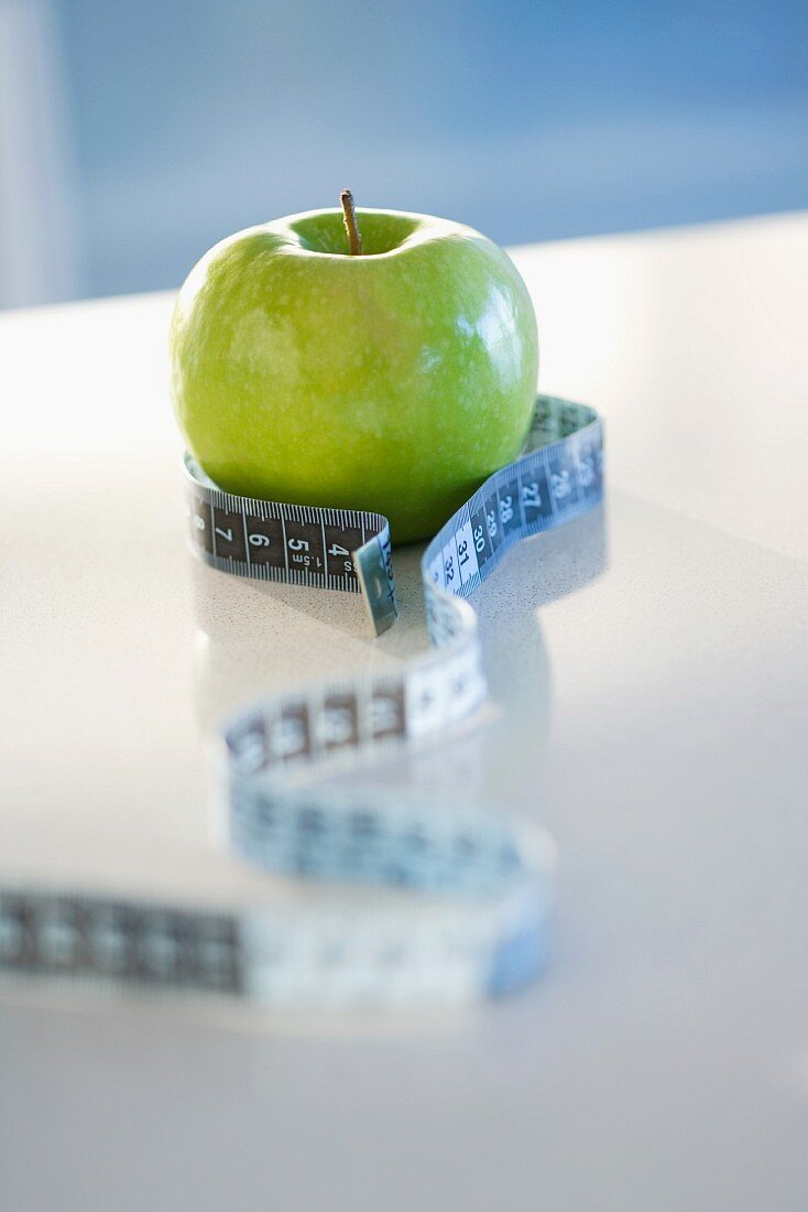 Green apple with tape measure