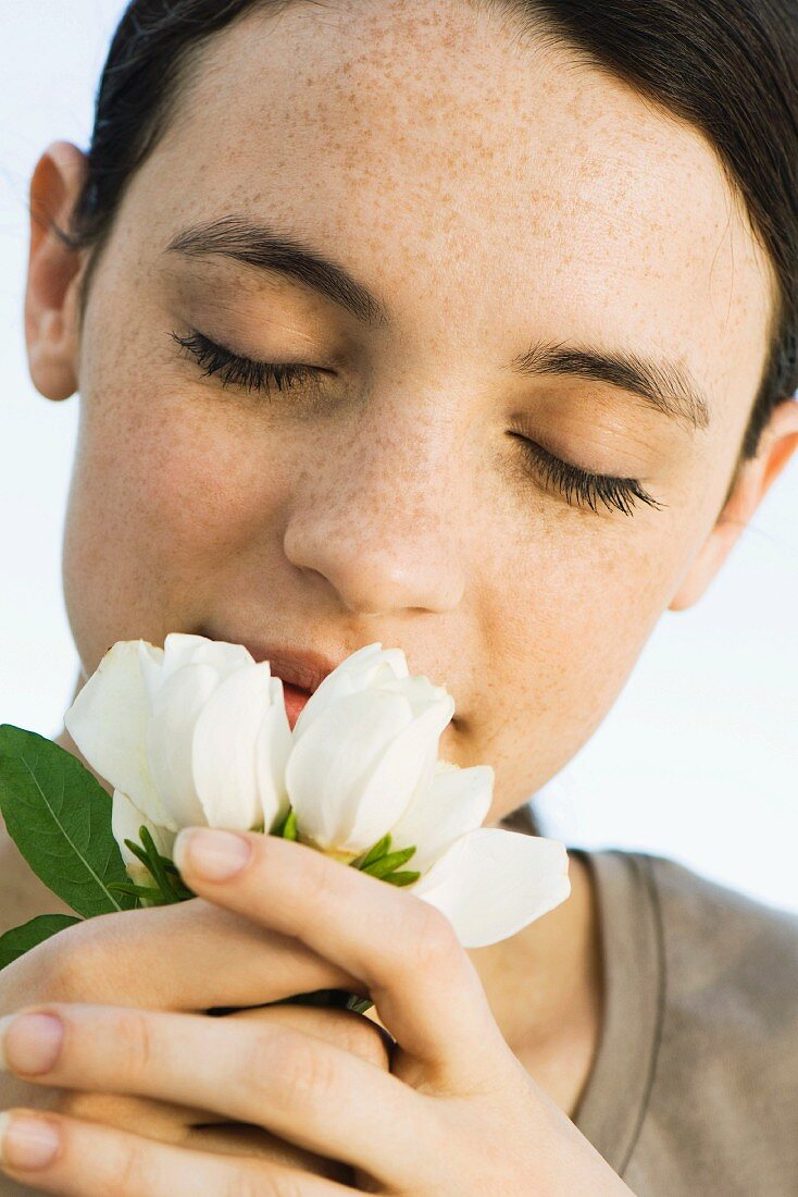 Young woman smelling flowers, close-up