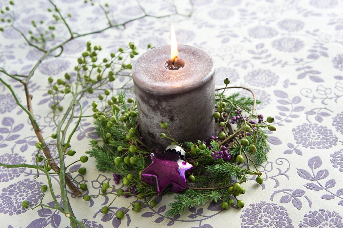 A Christmas decoration with a candle and twigs