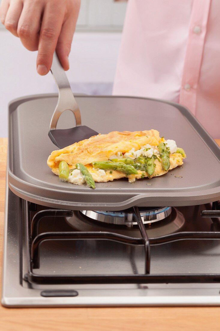 Omelett mit grünem Spargel und Feta auf dem heißen Stein