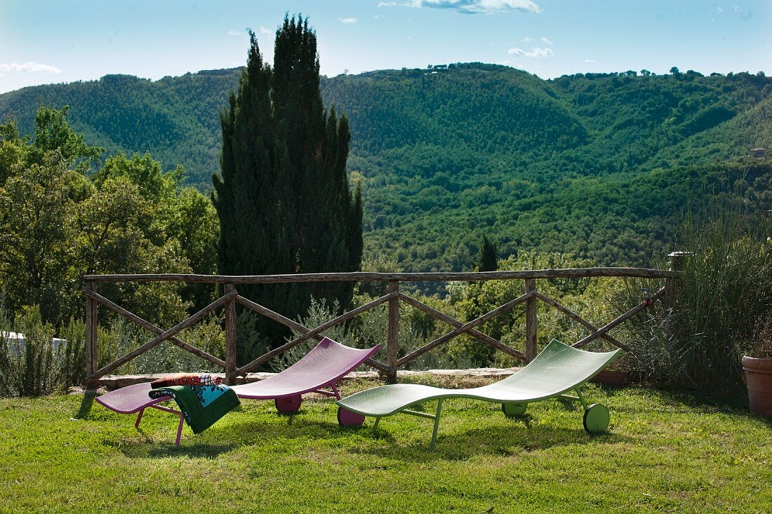 Moderne Sonnenliegen im Garten mit Blick über Berglandschaft