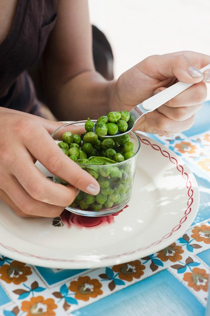 A woman eating peas with mint
