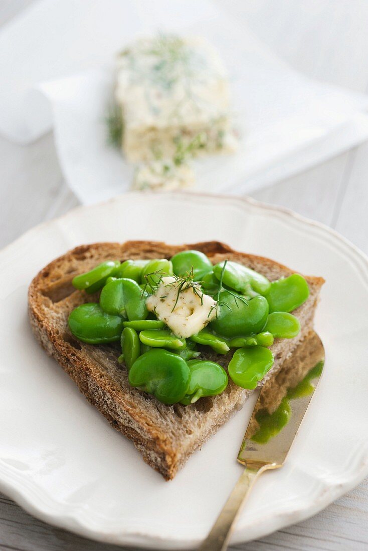 A slice of bread topped with peas and pastis butter