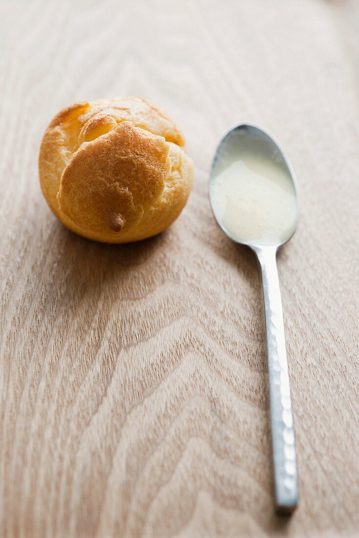 A profiterole and a spoonful of cream