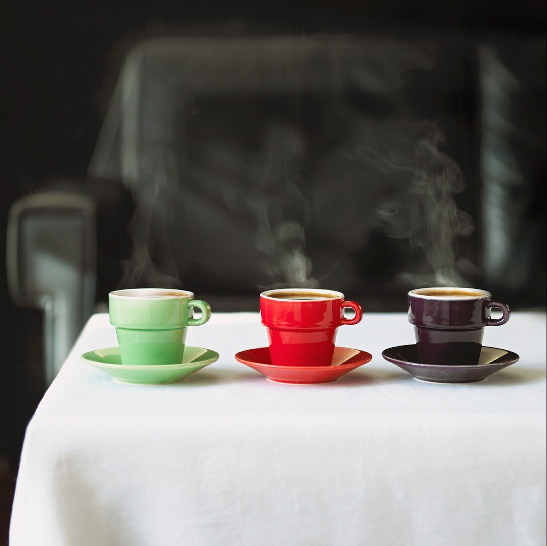 Grüne, rote & schwarze Tasse Kaffee auf Tisch stehend
