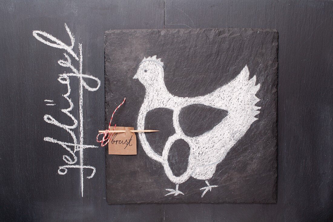 A sketch of a chicken and a written label on a chalkboard